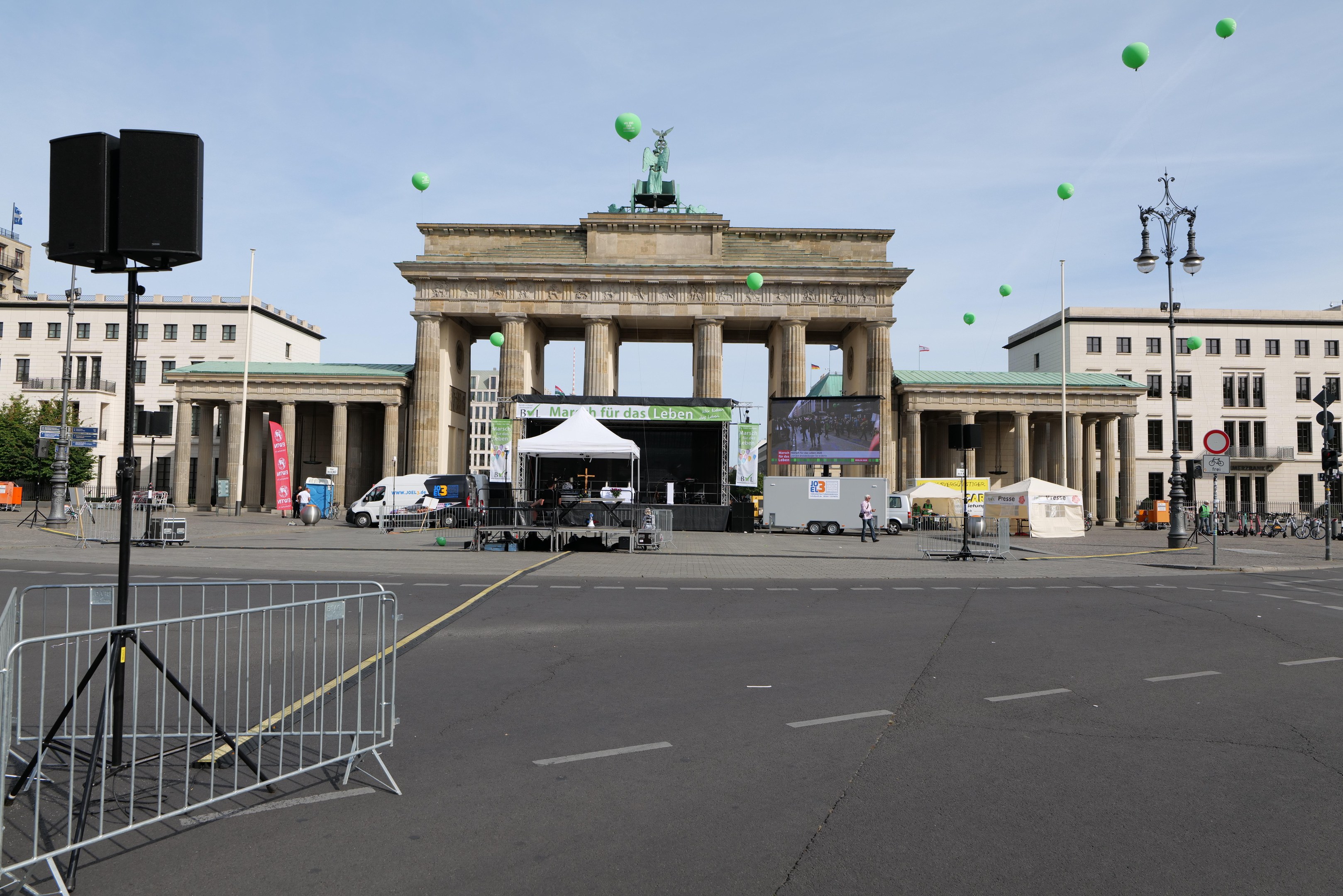 Brandenburger Tor in Berlin mit seinen klassizistischen Säulen und Statuen, umgeben von urbanen Elementen und festlichen grünen Luftballons während des Berlin-Marathons.