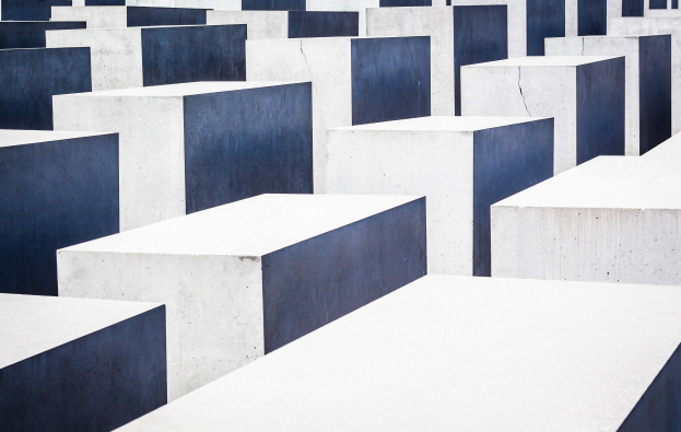 Das Holocaust-Mahnmal für die ermordeten Juden Europas in Berlin, das zahlreiche weiße und blaue Betonsteine in einem Gittermuster zeigt.