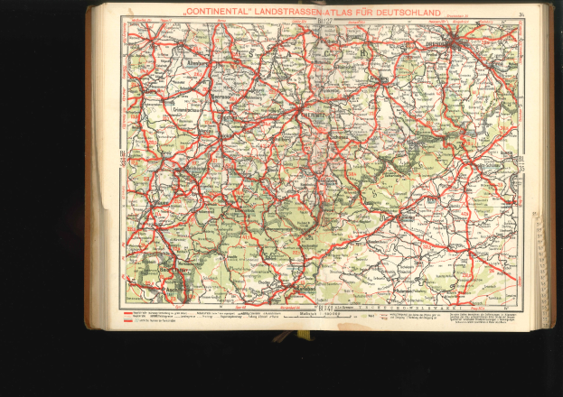 Offenes Buch mit einem detaillierten Kartenbild von Deutschlands Straßen und Autobahnen auf schwarzem Hintergrund.