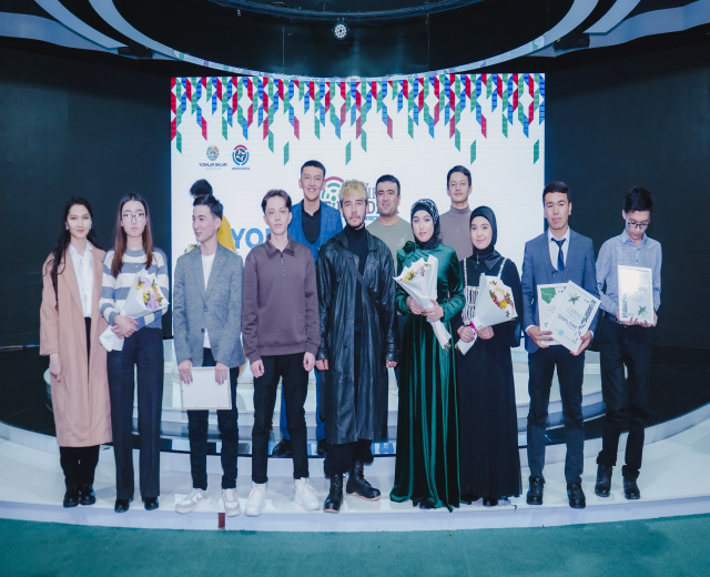 Gruppe von Menschen auf einer Bühne mit Blumensträußen und Urkunden, im Hintergrund ein 'Youth Solar Awards 2019'-Plakat