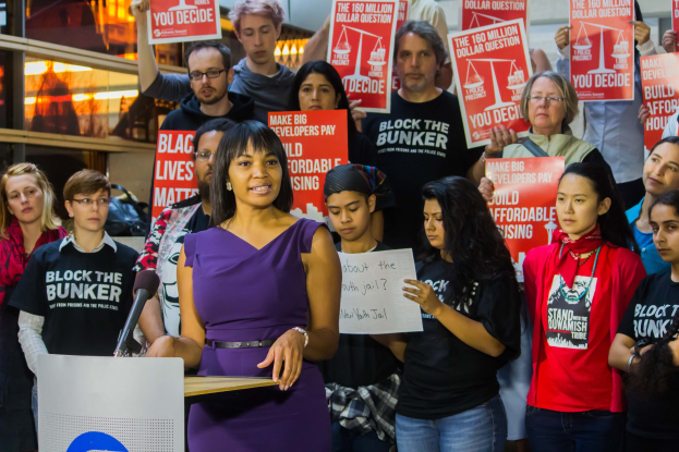 Eine Black Lives Matter-Aktivistin, die vor einer Menge mit Schildern spricht.