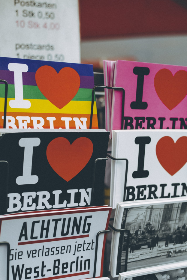 Ein Displayständer mit Büchern und Postern, auf denen der Satz "Ich liebe Berlin" steht, vor einem sanft unscharfen Hintergrund.