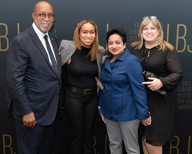 Vier Personen posieren auf einem roten Teppich bei den Liberty Justice for All Awards und lächeln für ein Foto.