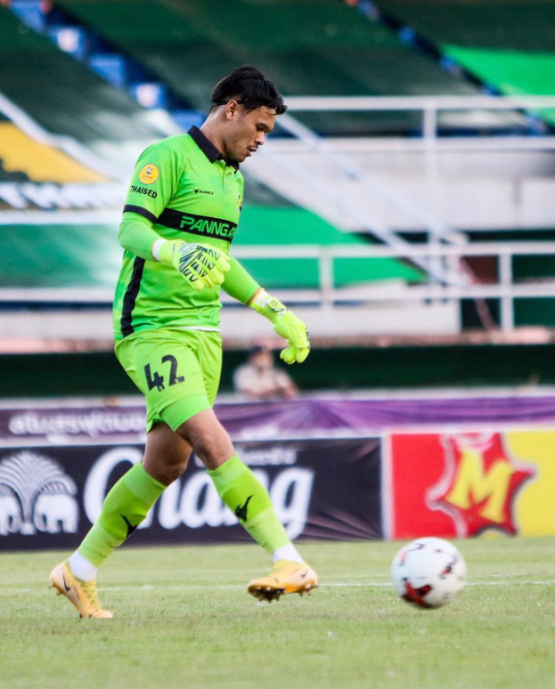 Ein Torwart in einem grünen Trikot schießt einen Fußball auf einem Rasenfeld während eines Matches zwischen Chivas USA und Mexico City in der Copa Libertadores, wie durch Banner im Hintergrund angezeigt.
