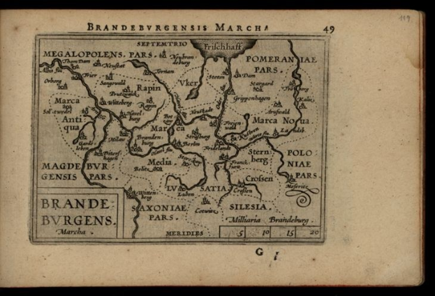 Altes Buch mit einer detaillierten Karte der brandenburgischen Region Deutschlands auf einem schwarzen Hintergrund, das geografische Merkmale und Text über die Region zeigt.