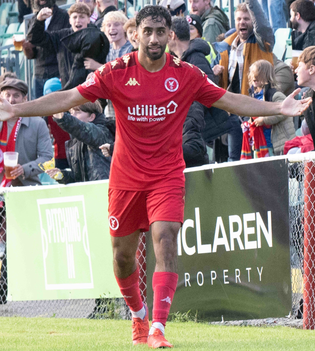 Ein Fussballspieler In Roter Uniform Läuft Mit Ausgestreckten Armen Auf Einem Feld, Umgeben Von Zuschauern, Mit Einem "Middlesbrough FC V Swansea City - Sky Bet Championship"-Schild Im Hintergrund.