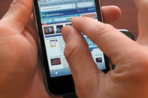 Eine Person hält ein Handy mit Text auf dem Display.